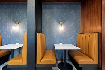 A restaurant with orange booths and tables.