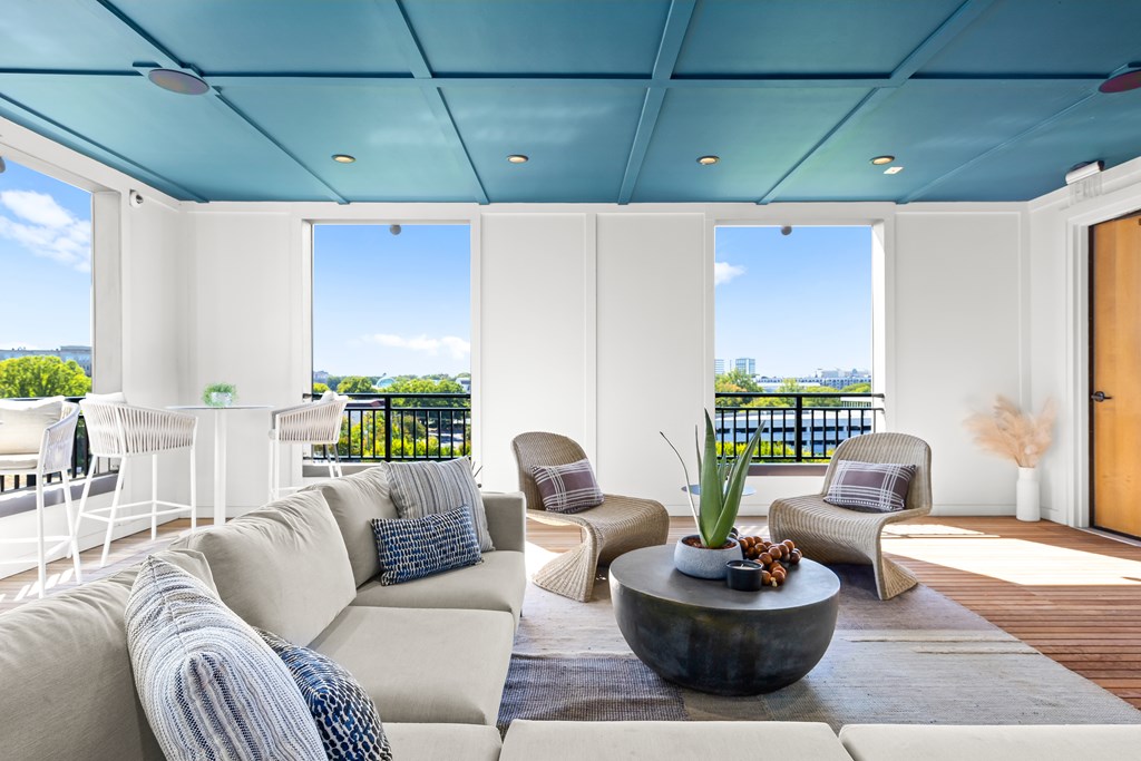 A modern living room with a large sofa and a view of the ocean.
