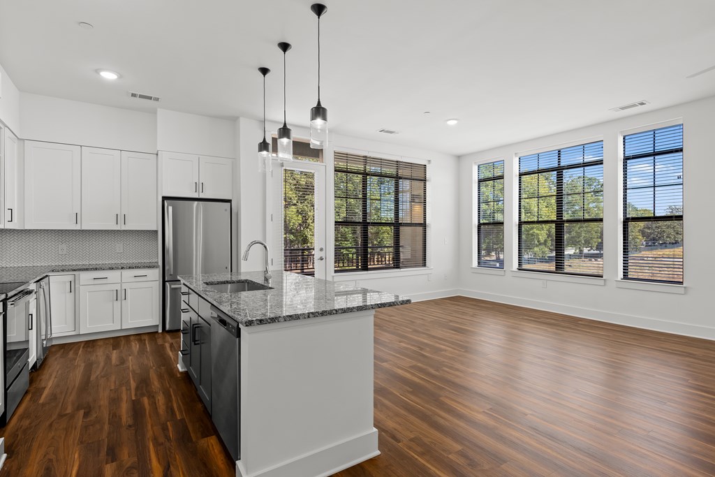 A modern kitchen with wooden floors and a large island.