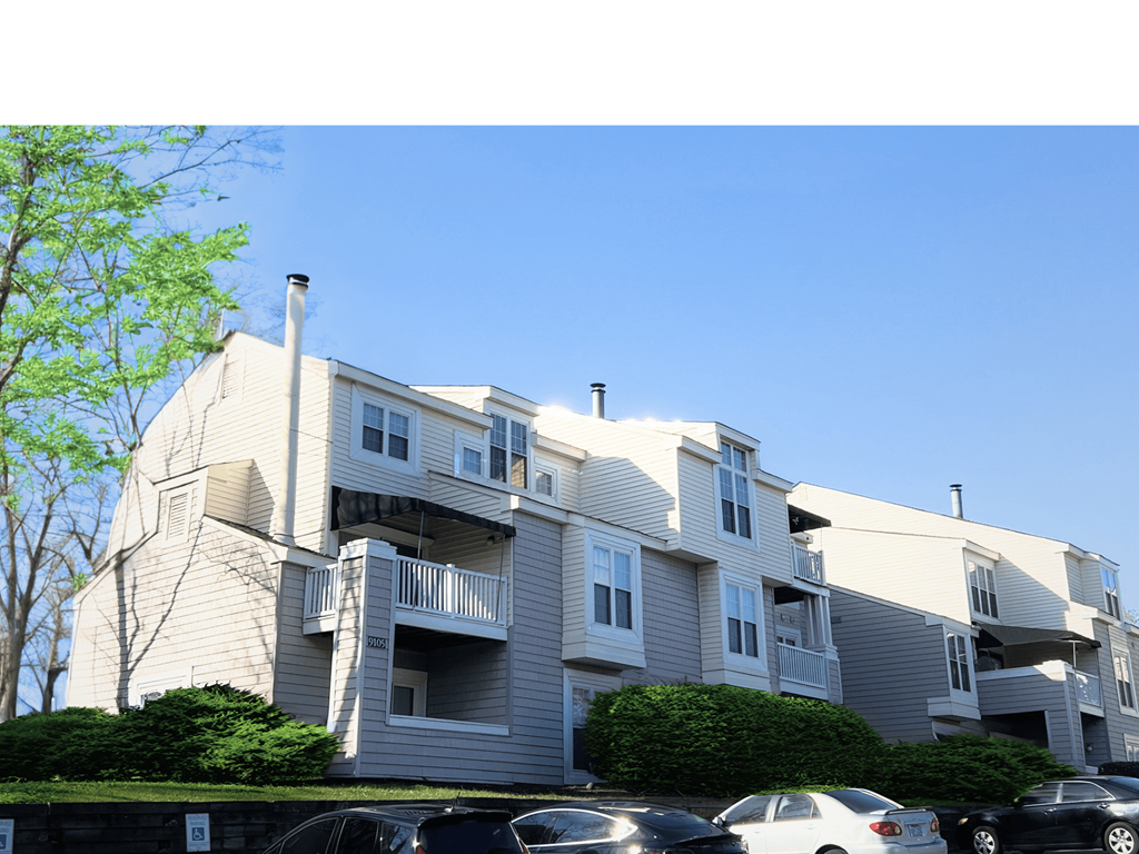 a large apartment building with cars parked in front of it