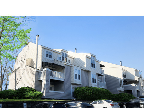 a large apartment building with cars parked in front of it