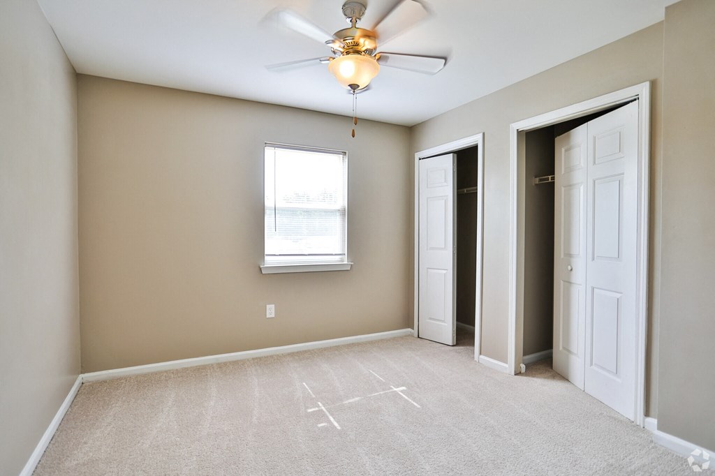A room with a ceiling fan and a window.