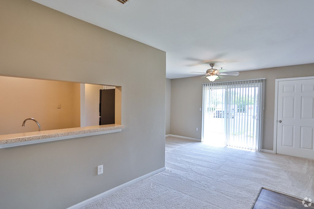 A room with a ceiling fan and a window with blinds.
