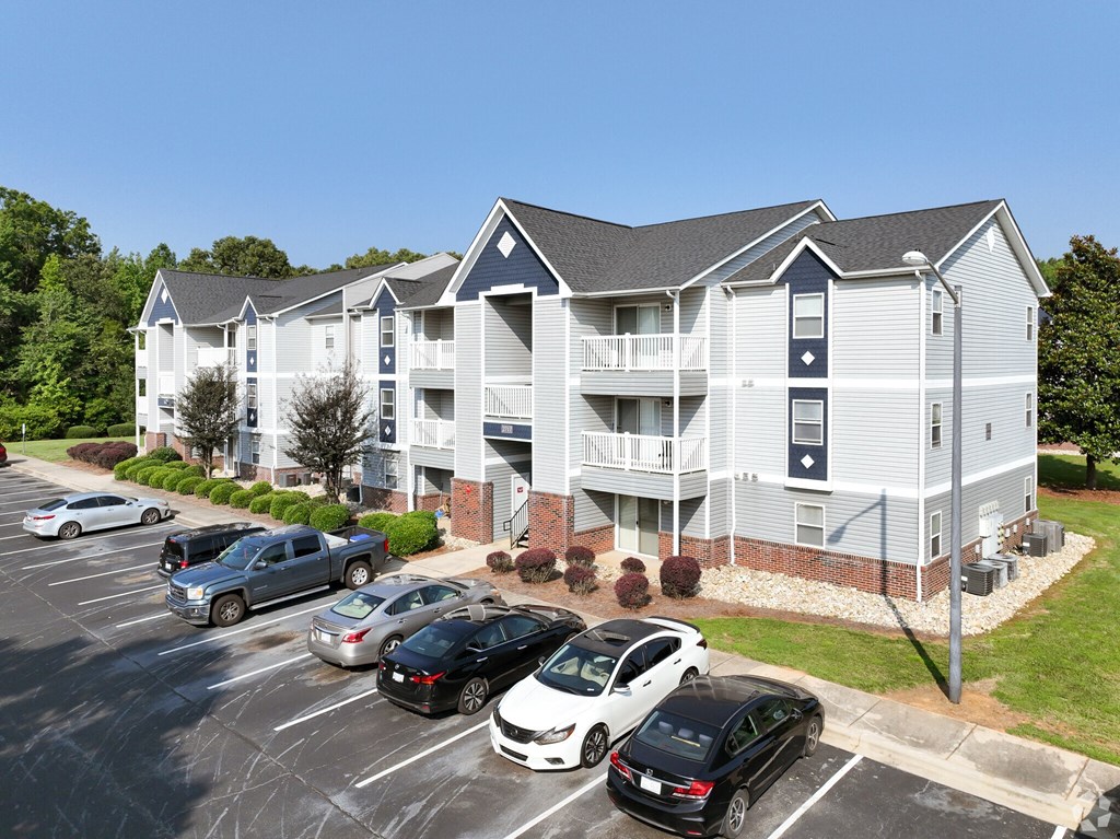 A parking lot with cars and a building in the background.