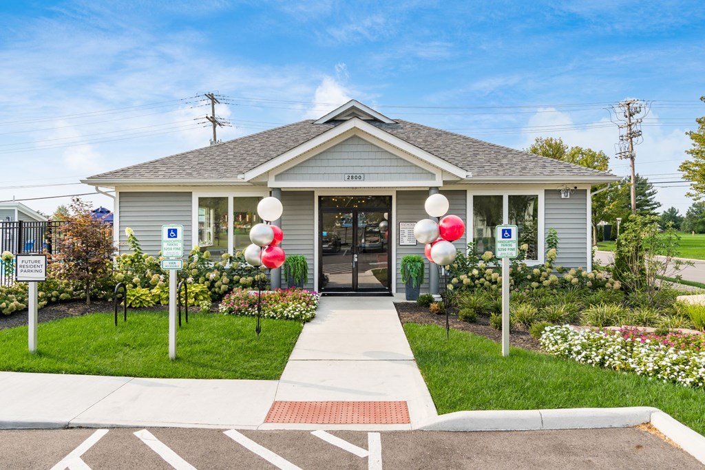 A small building with a grey roof and a sign that says 