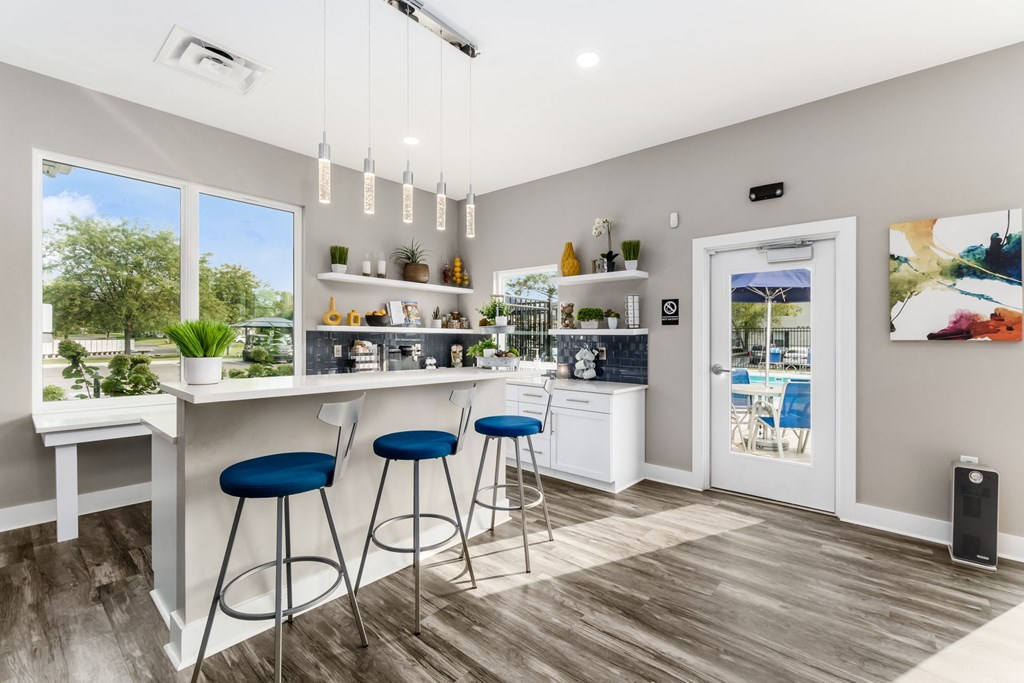 A modern kitchen with blue stools and a white countertop. at Estates at Brentwood Lake Apartments, Reynoldsburg, Ohio