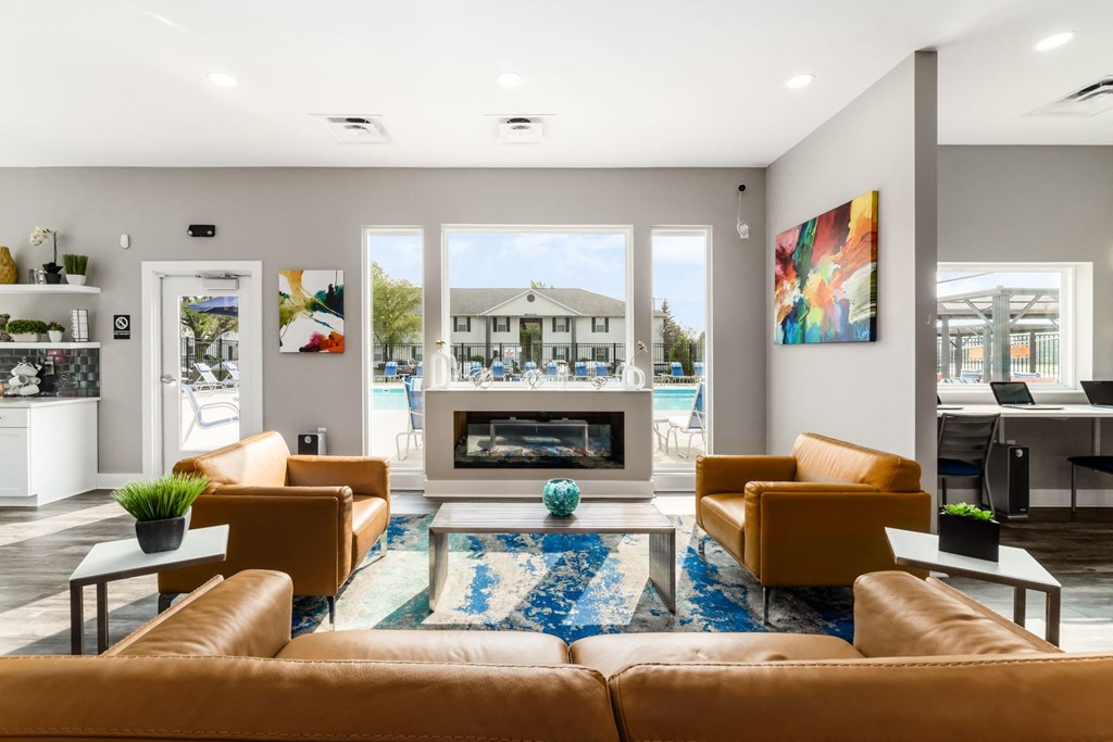 A living room with a fireplace and a view of a house across the street at Estates at Brentwood Lake Apartments, Reynoldsburg, OH