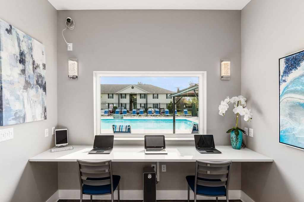 A room with a desk and laptops with a pool in the background at Estates at Brentwood Lake Apartments, Reynoldsburg