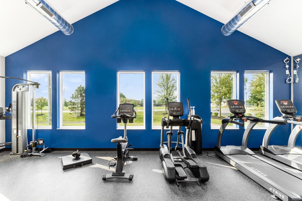 A gym with treadmills, exercise bikes, and elliptical machines at Estates at Brentwood Lake Apartments, Reynoldsburg, OH