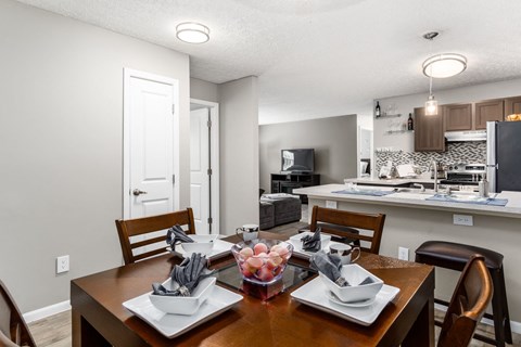 a dining room table with a kitchen in the background