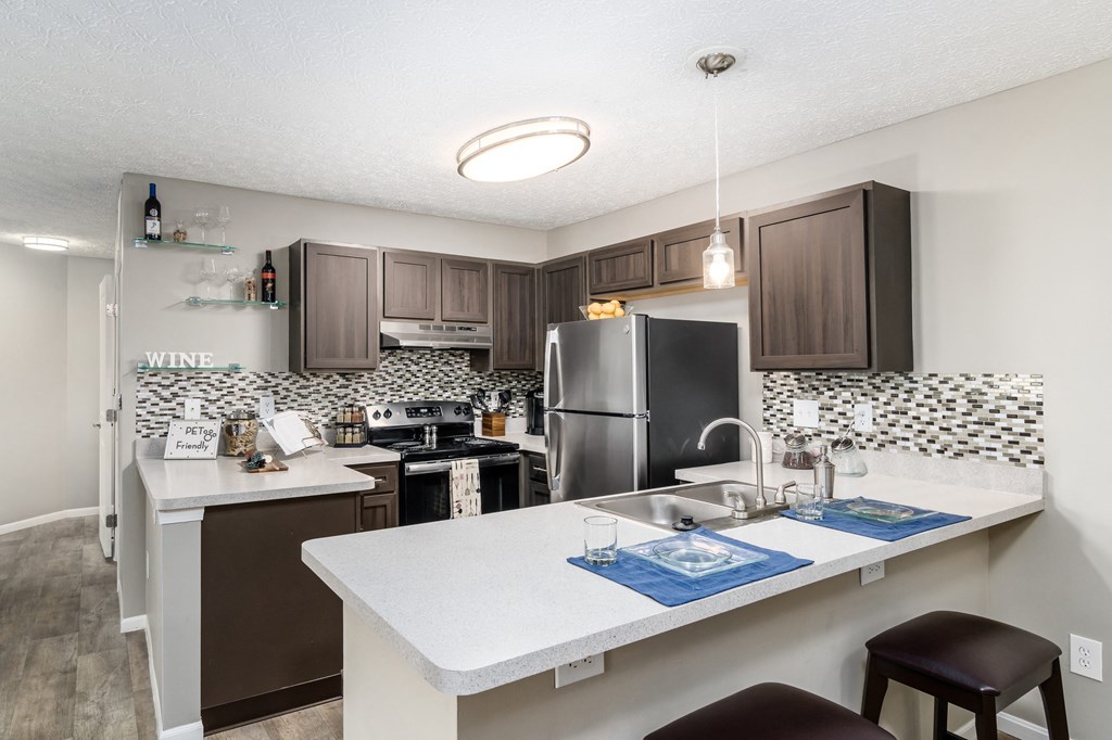 A kitchen with a white counter top and brown cabinets at Estates at Brentwood Lake Apartments, Reynoldsburg, 43068