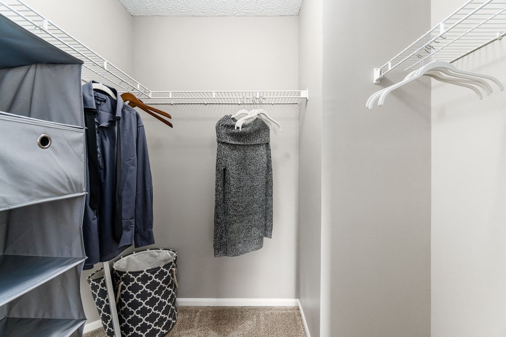 A small closet with a coat hanging on the rack at Estates at Brentwood Lake Apartments, Ohio