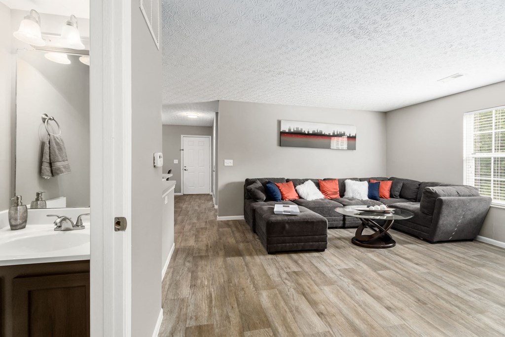 A living room with a grey couch and a wooden floor at Estates at Brentwood Lake Apartments, Ohio