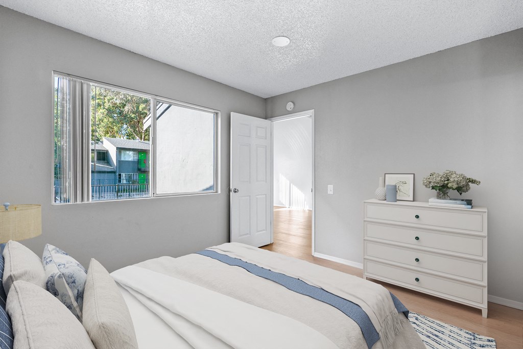 a bedroom with a bed and a dresser and a window