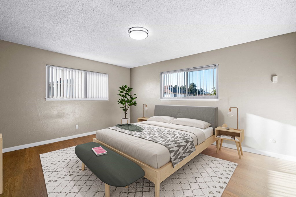 a bedroom with a bed and two windows