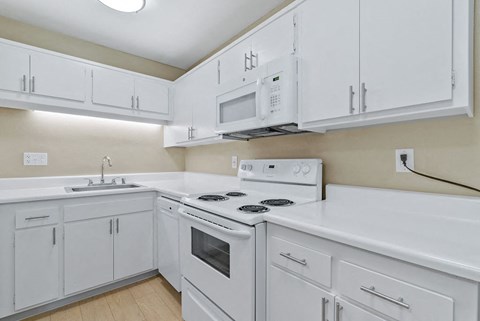 a white kitchen with white appliances and white cabinets