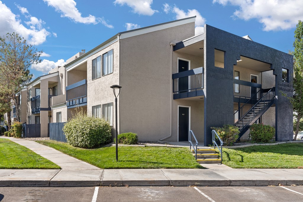 an apartment building with stairs and a sidewalk
