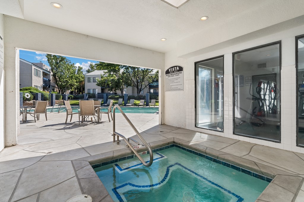 the private hot tub and pool area of a resort style swimming pool in a patio