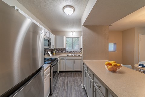 a kitchen with stainless steel appliances and white cabinets