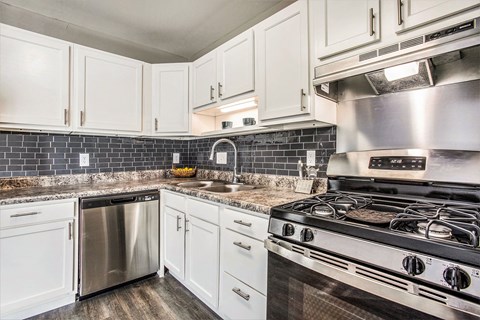 a kitchen with stainless steel appliances and white cabinets