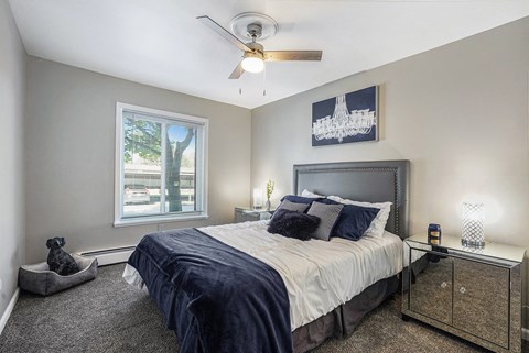 the master bedroom has a large bed and a ceiling fan