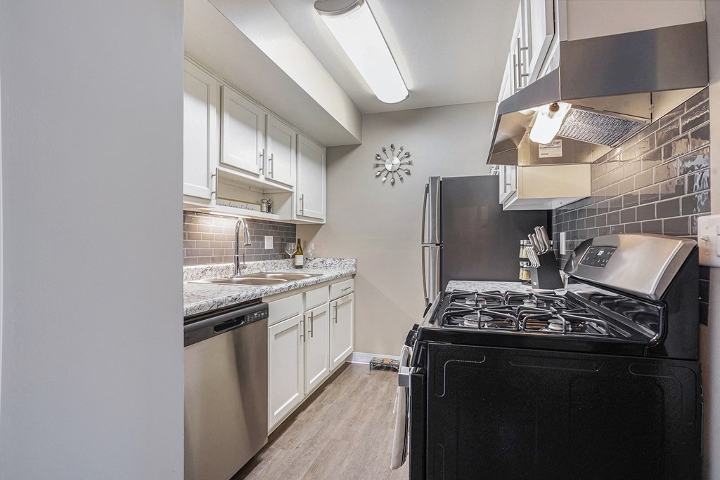 a kitchen with stainless steel appliances and a black stove