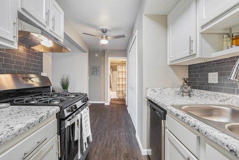 a kitchen with white cabinets and a stove and a sink