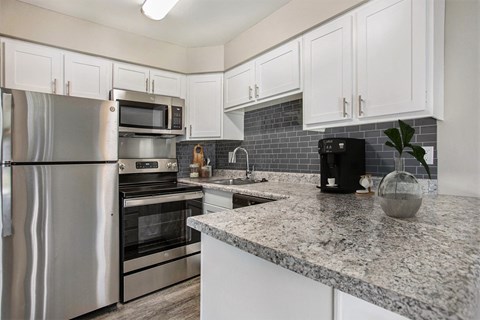 a kitchen with granite counter tops and stainless steel appliances