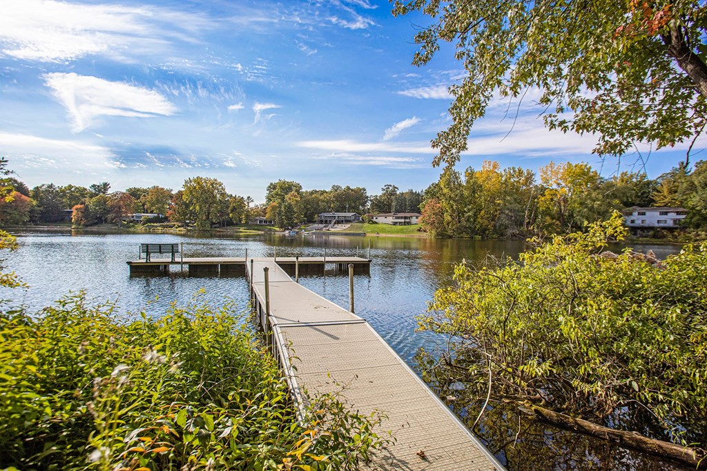 a dock on a lake with a house in the background