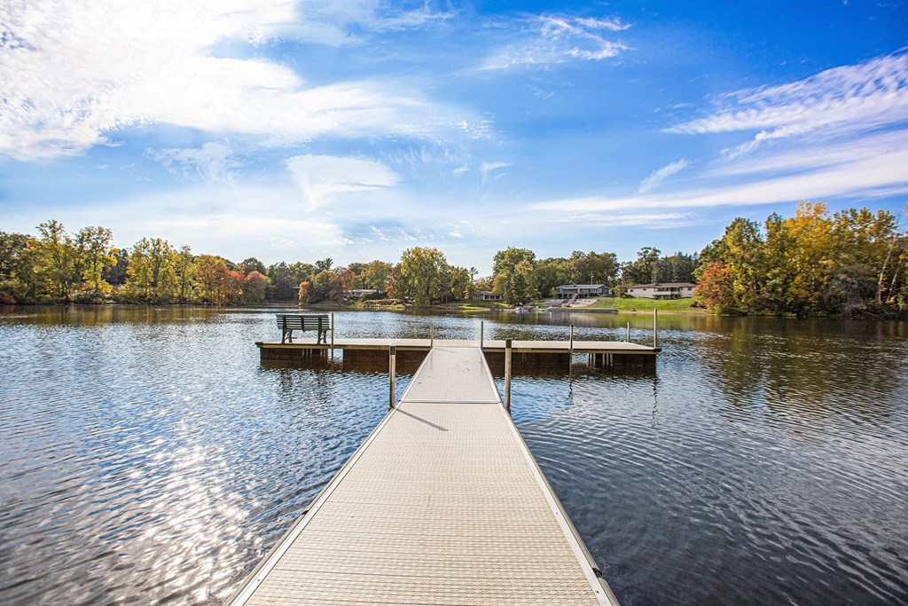 a dock on a lake with trees in the background