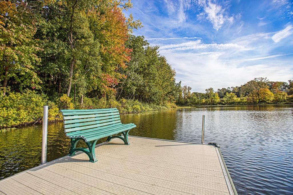 a park bench on a dock overlooking a lake