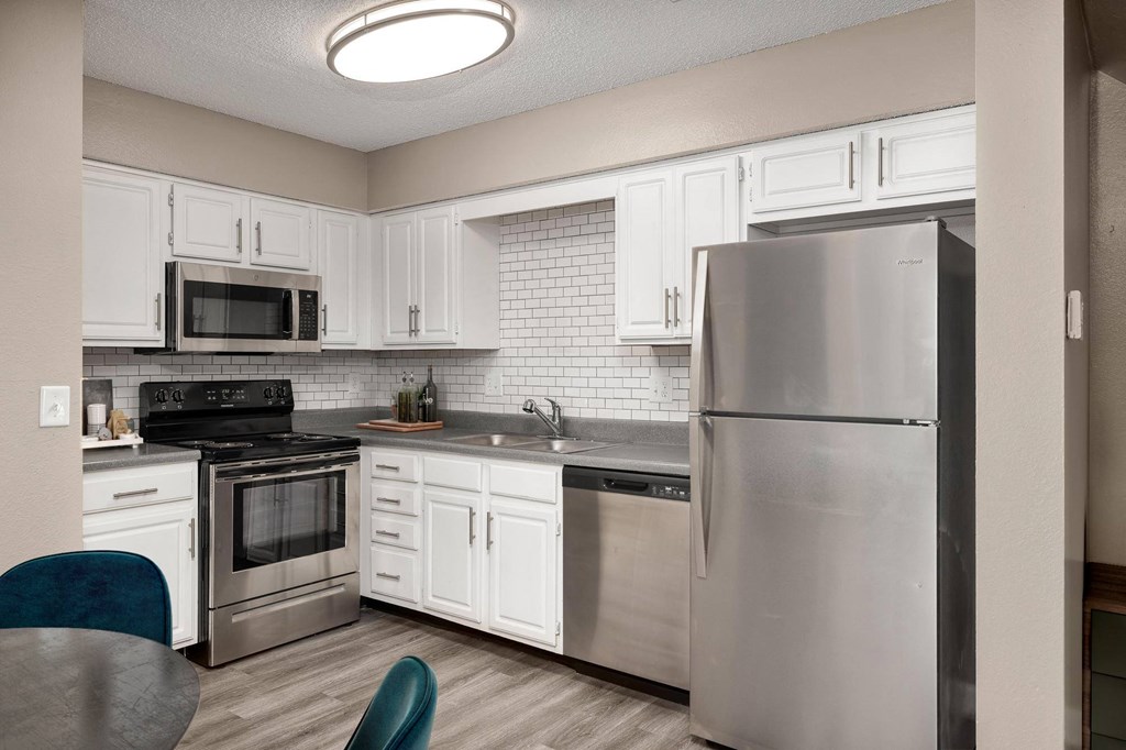 a kitchen with stainless steel appliances and white cabinets