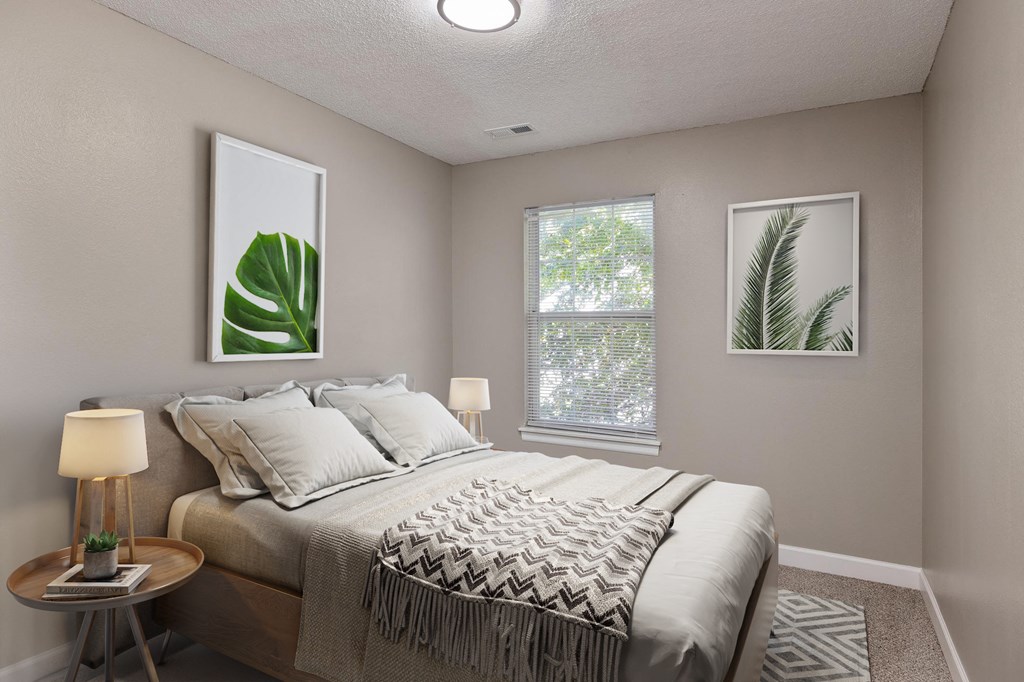 an empty bedroom with a bed and two windows