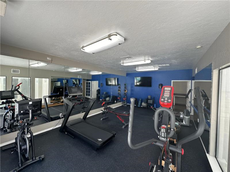A gym with treadmills, exercise bikes, and other equipment.
