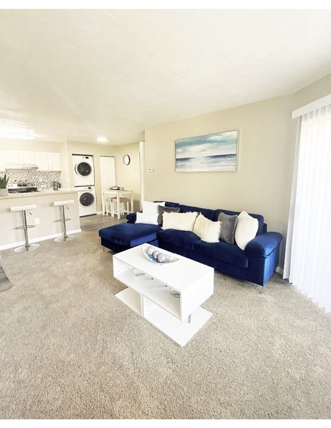 a living room with a blue couch and a white coffee table