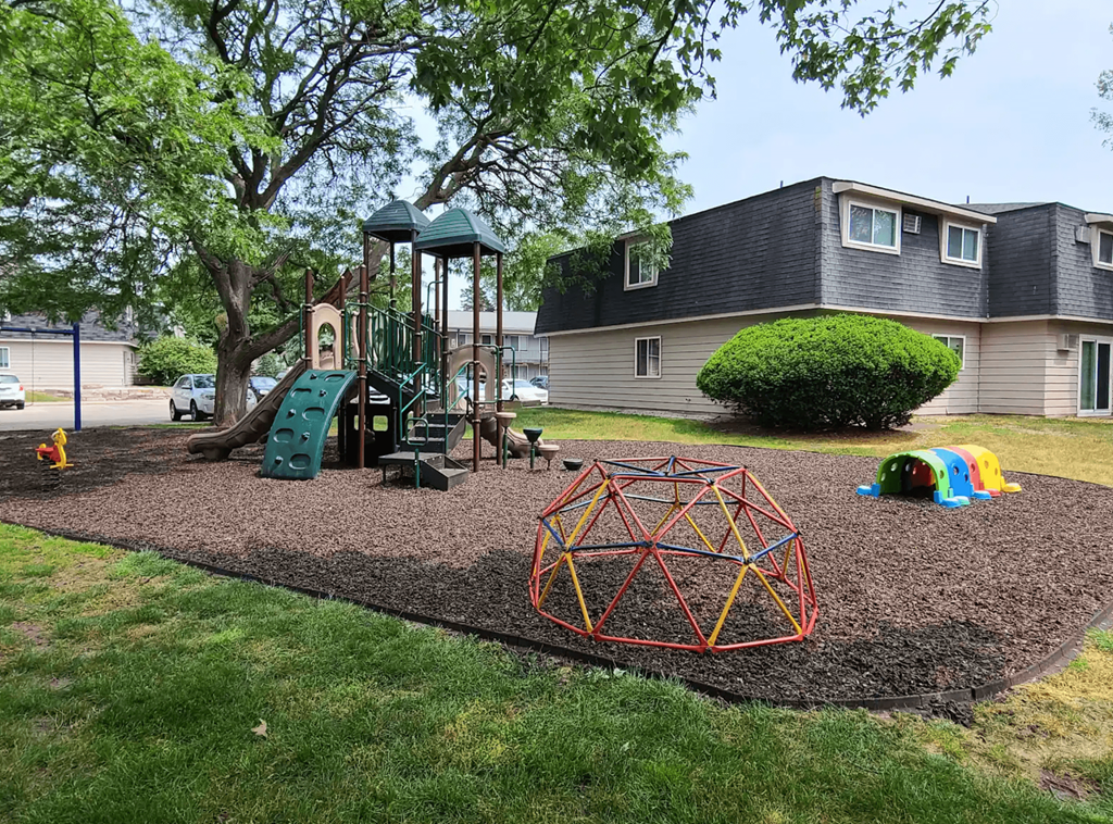 A playground with a swing set, a slide, and a climbing structure.