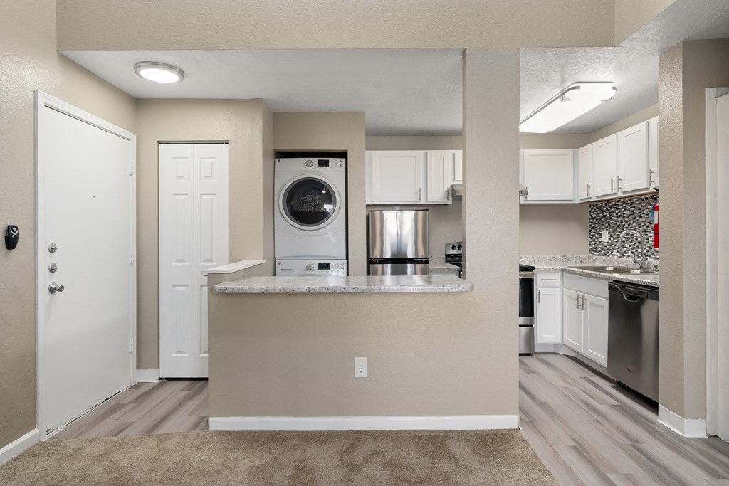 an empty kitchen with a washer and dryer in it