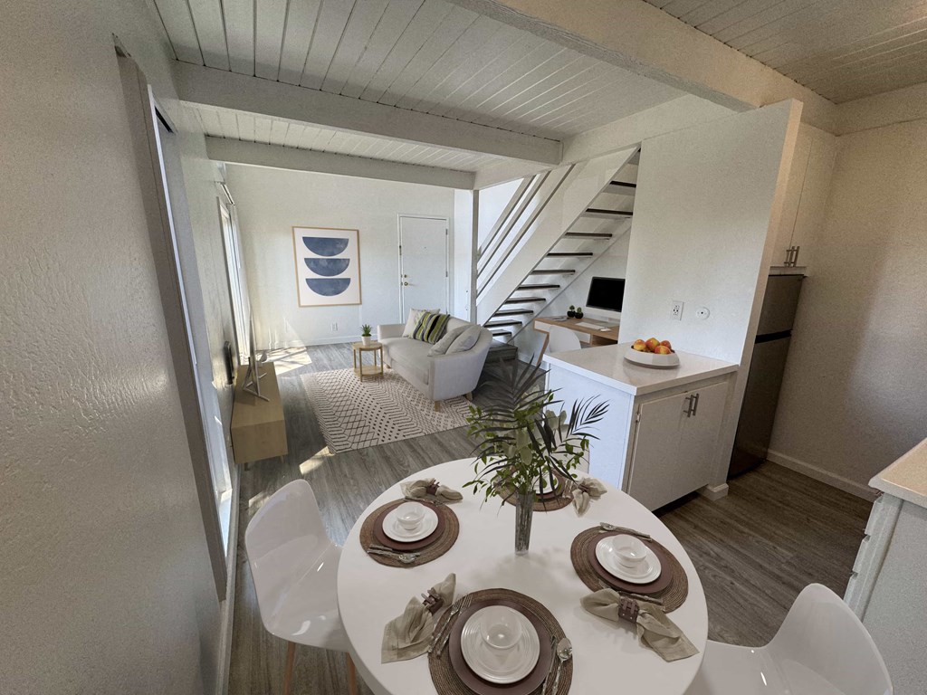 a living room and dining room with a table and chairs