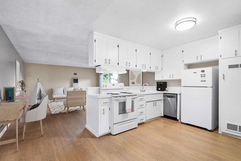 a kitchen with white cabinets and appliances and a dining table