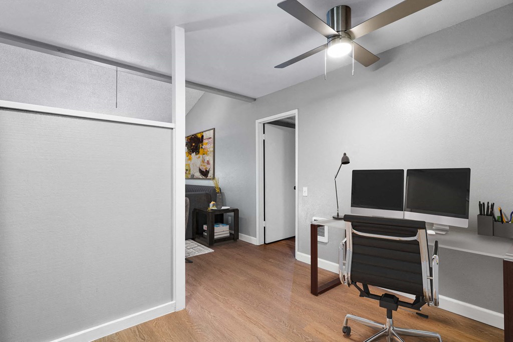 a living room with a desk and a tv