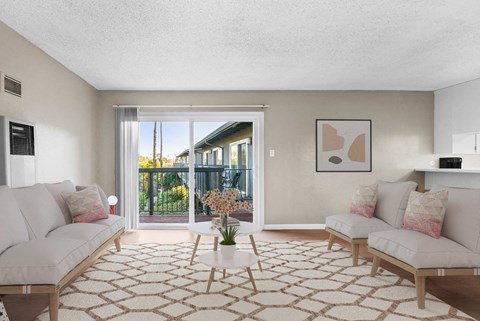 a living room with two white couches and a sliding glass door