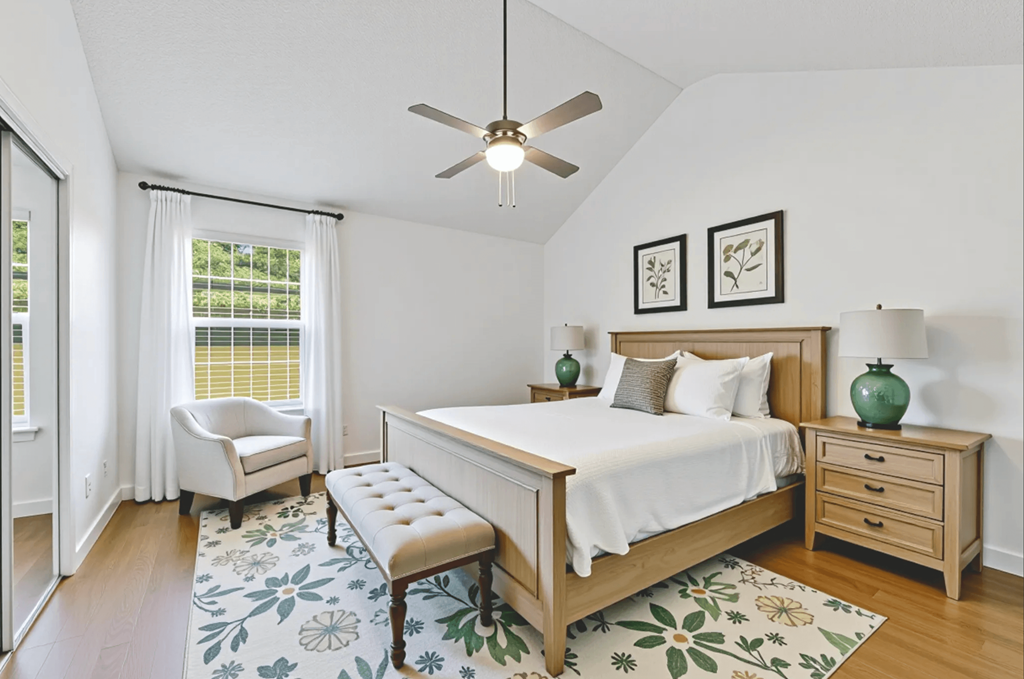 A bedroom with a bed, bench, and two framed pictures on the wall.