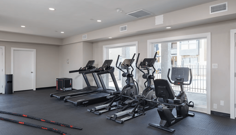 A spacious gym with treadmills, elliptical machines, and other exercise equipment.