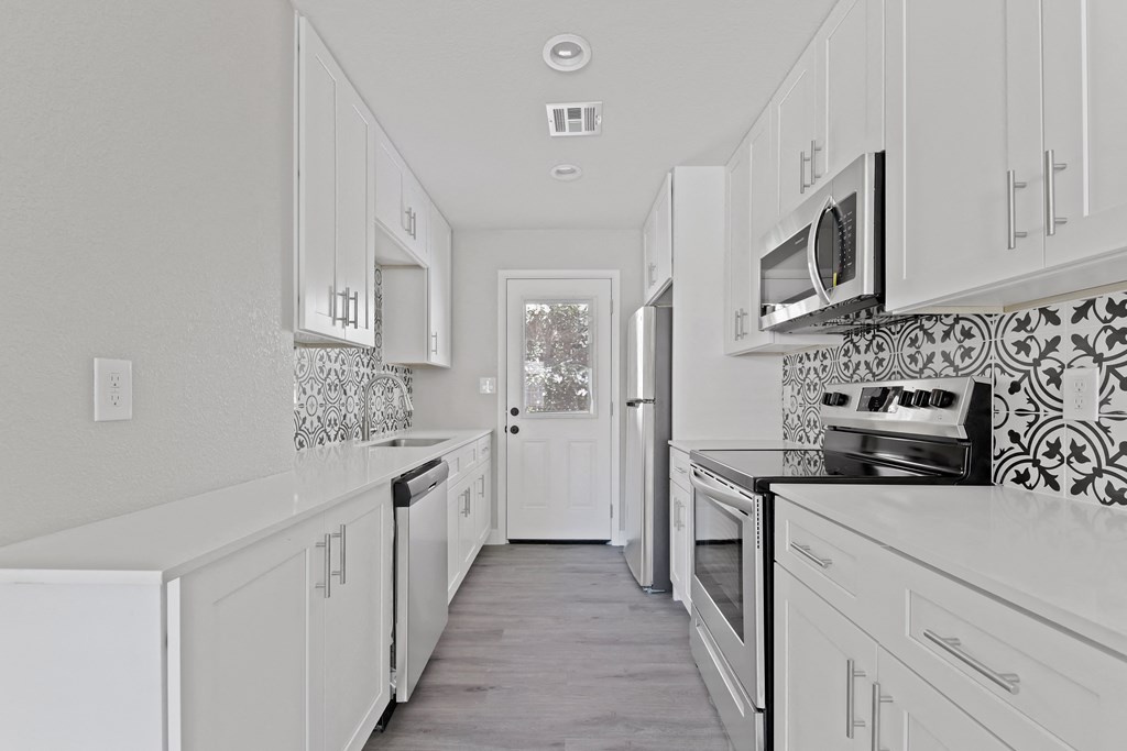 a white kitchen with white cabinets and white appliances