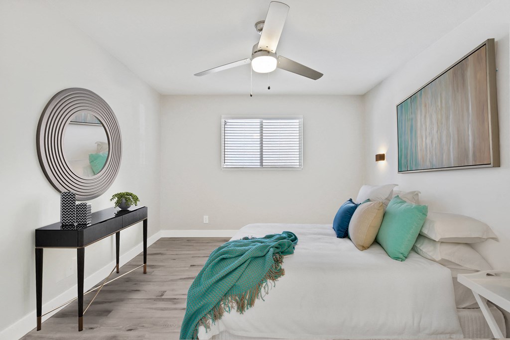 a bedroom with a large bed and a ceiling fan
