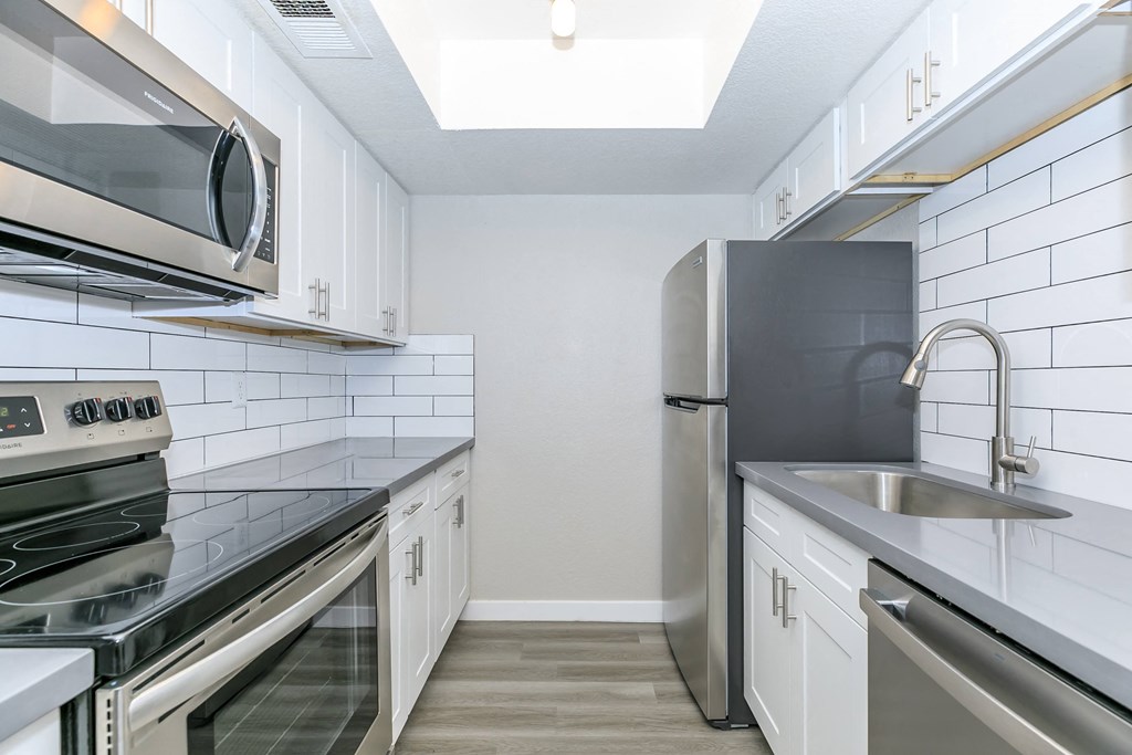 a kitchen with stainless steel appliances and white cabinets at Tides on Southern, Mesa, AZ 85204