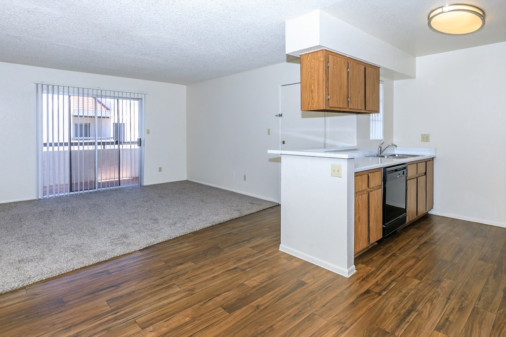 an empty kitchen and living room with wood flooring and a window at Tides on Southern, Mesa, AZ 85204