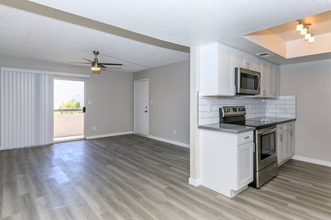 an empty kitchen and living room with a ceiling fan