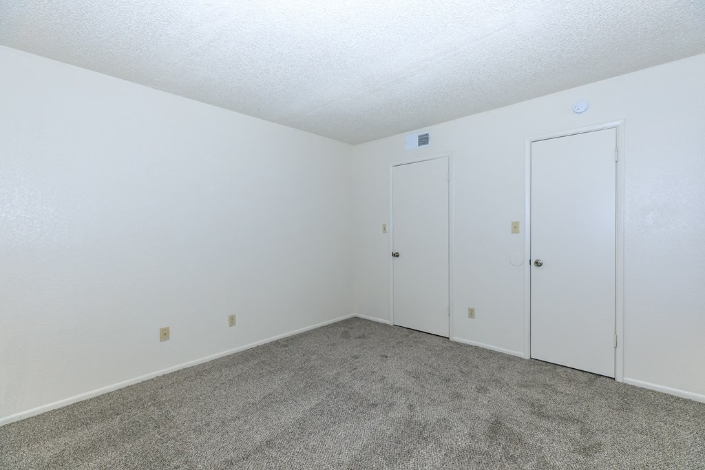 an empty room with carpet and white doors at Tides on Southern, Arizona, 85204