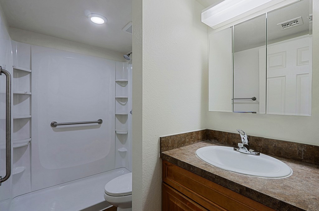 A white bathroom with a sink and a mirror.